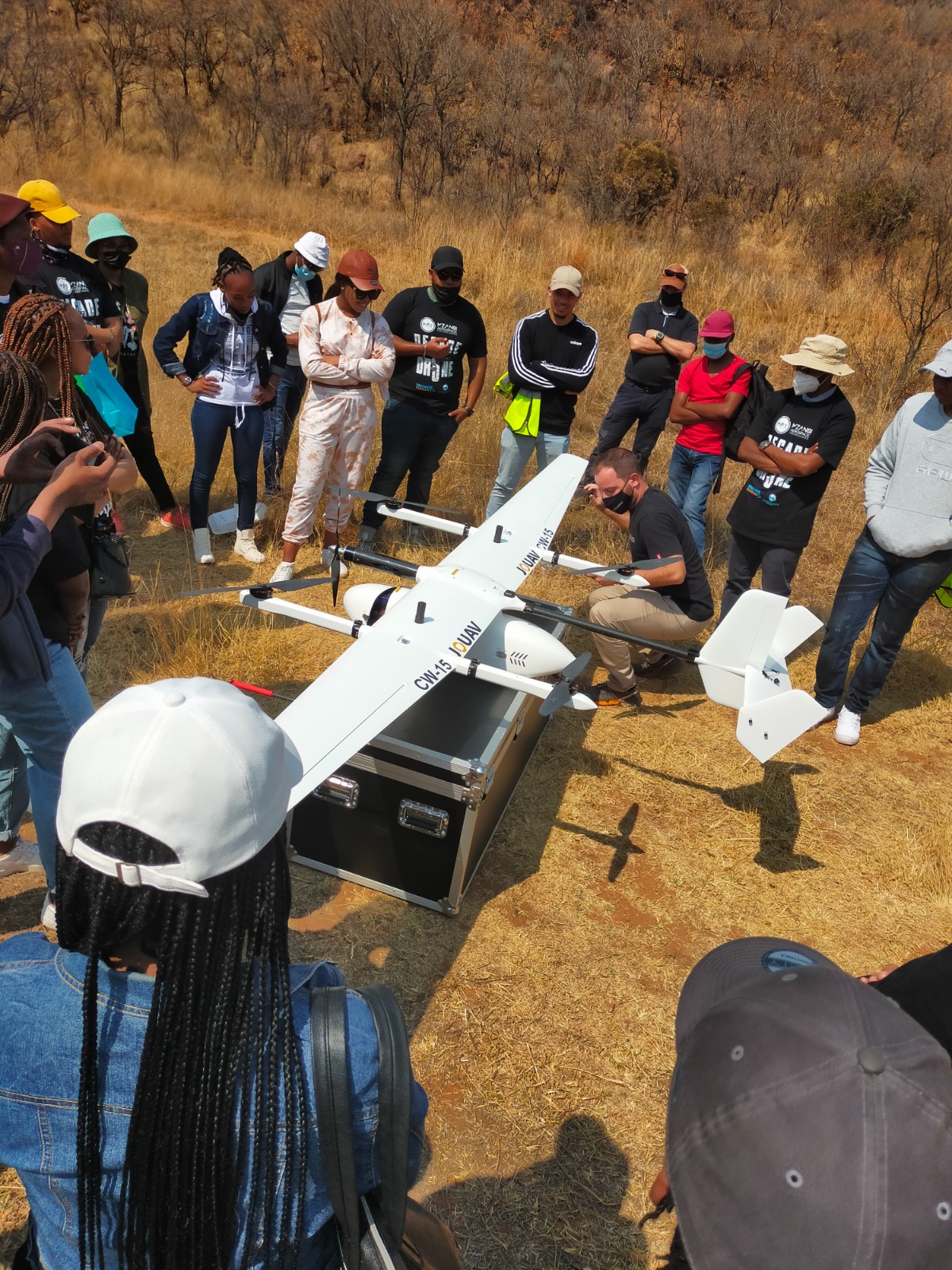 Rural learners gathered around drone technology during a practical learning session